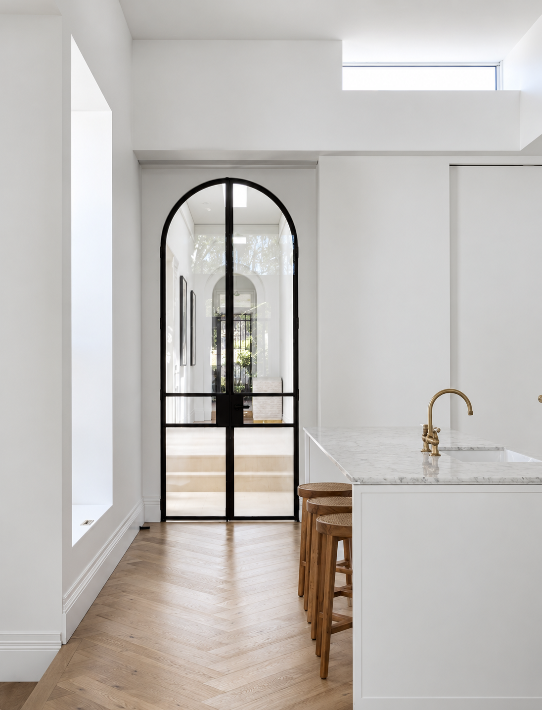 Bright kitchen with a black arched glass doorway
